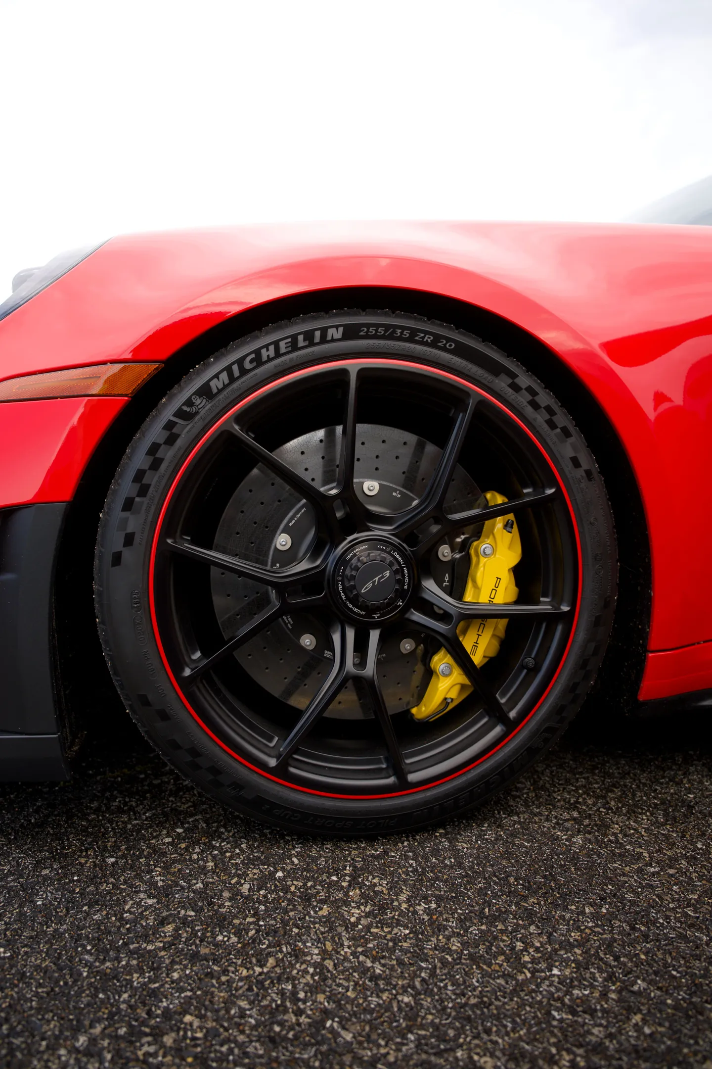 La jante noire et l’étrier jaune d’une Porsche 911 GT3 rouge