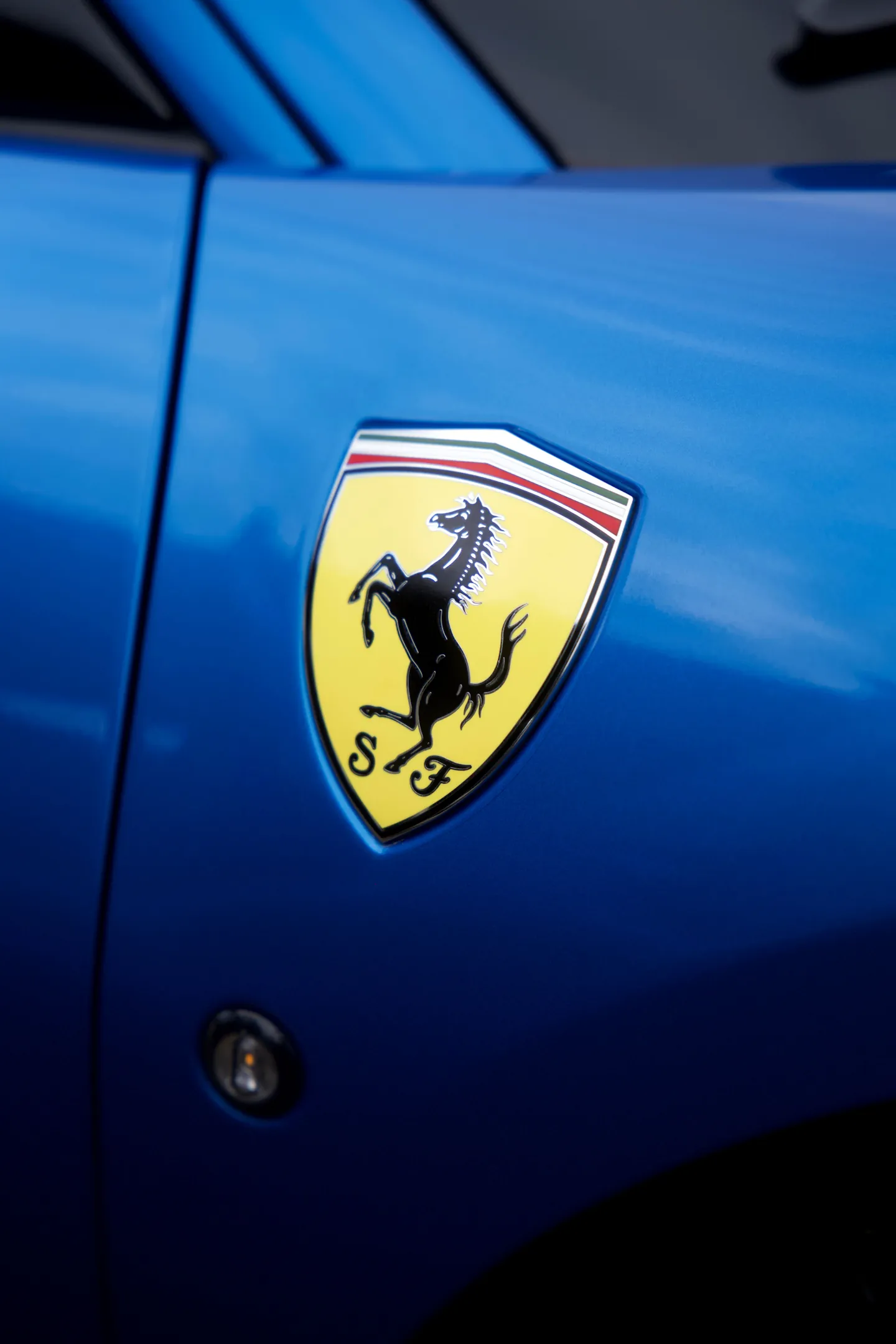 L’écusson Ferrari sur l’aile d’une Ferrari bleue
