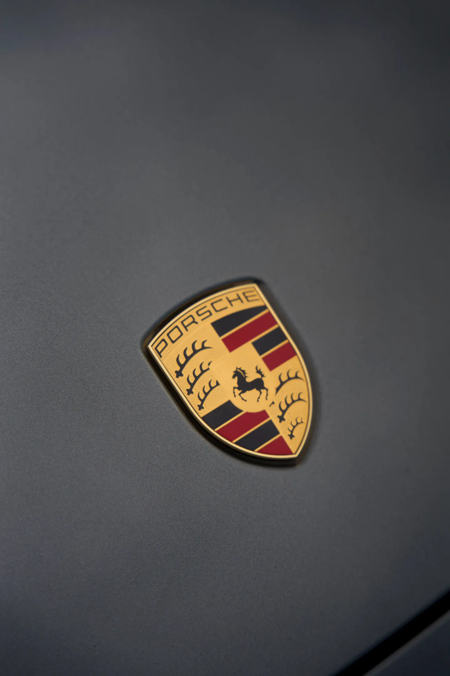 L’écusson Porsche sur un capot gris mat