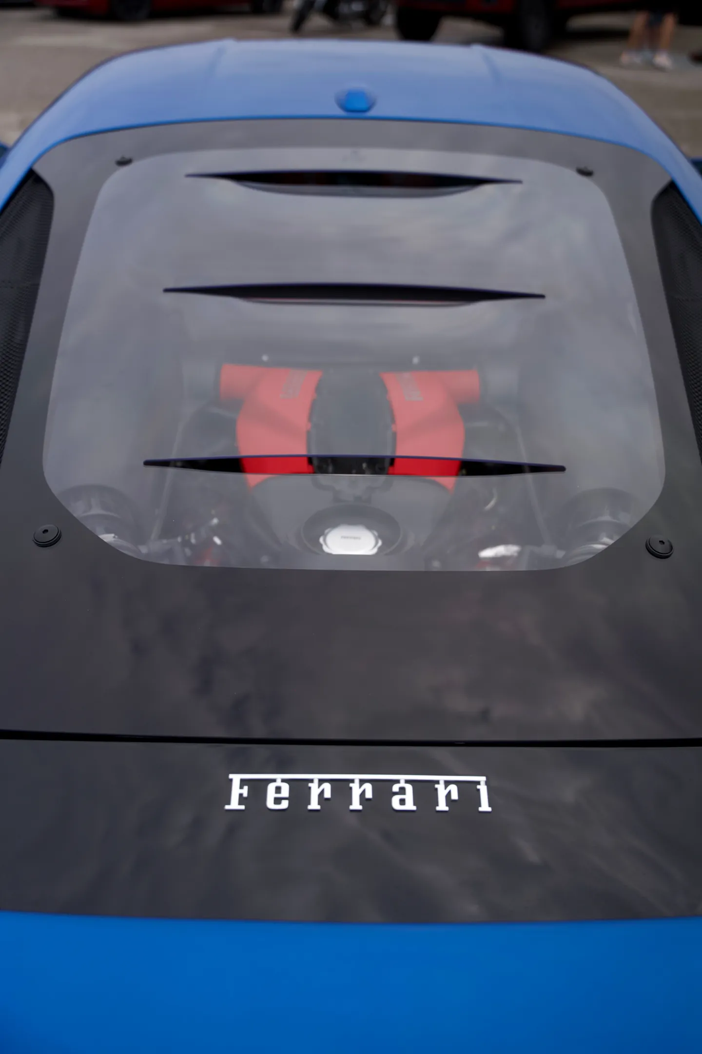 Le capot moteur vitré d’une Ferrari bleue