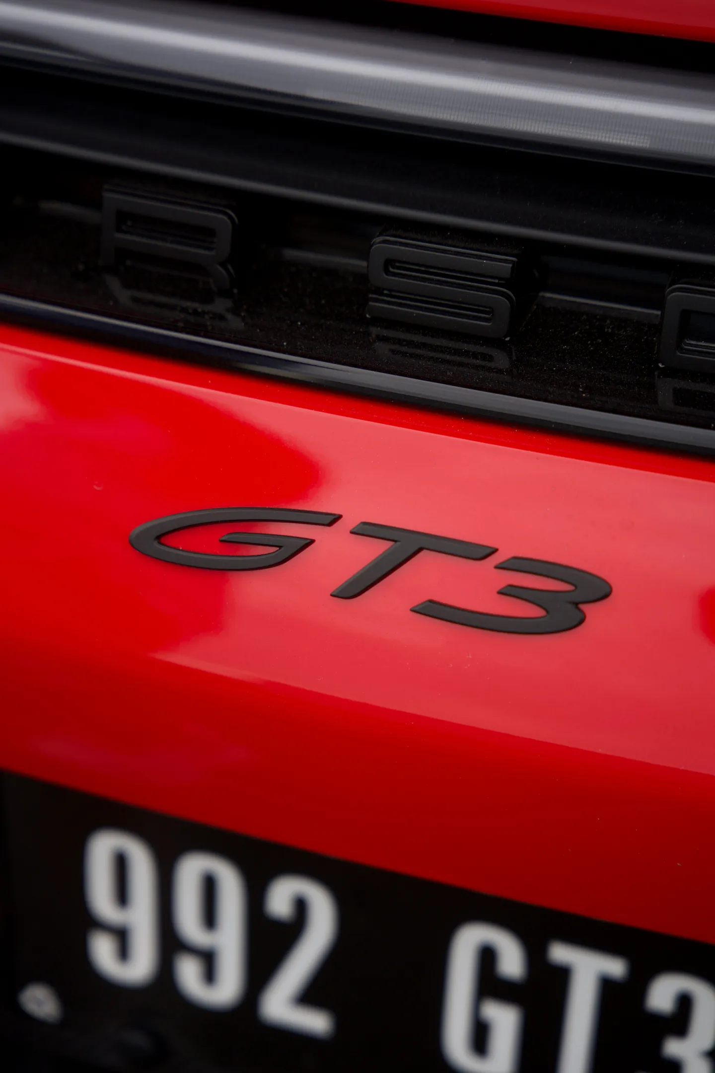 Le logo GT3 à l’arrière d’une Porsche rouge
