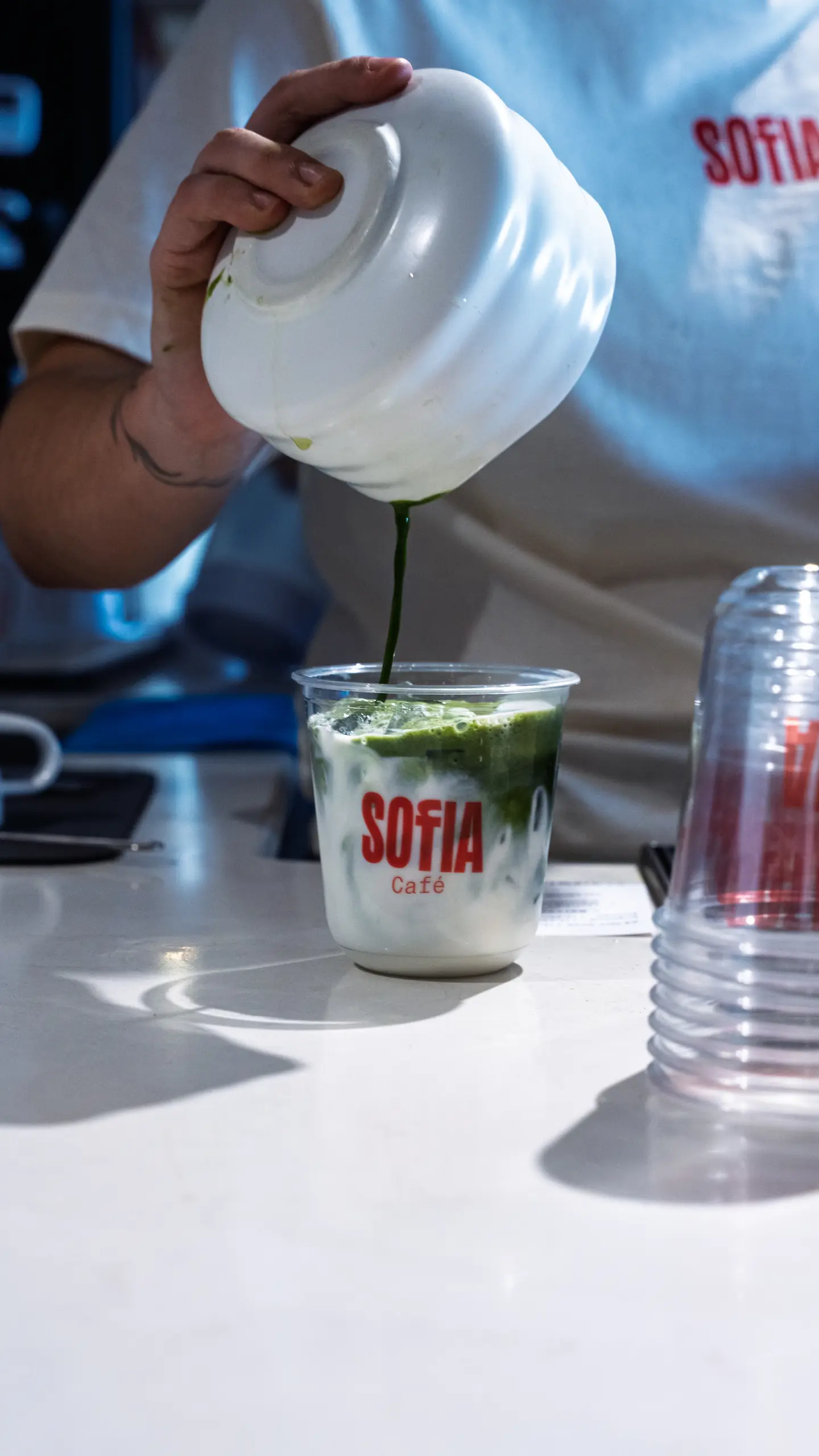Matcha poured over milk in a Sofia cup