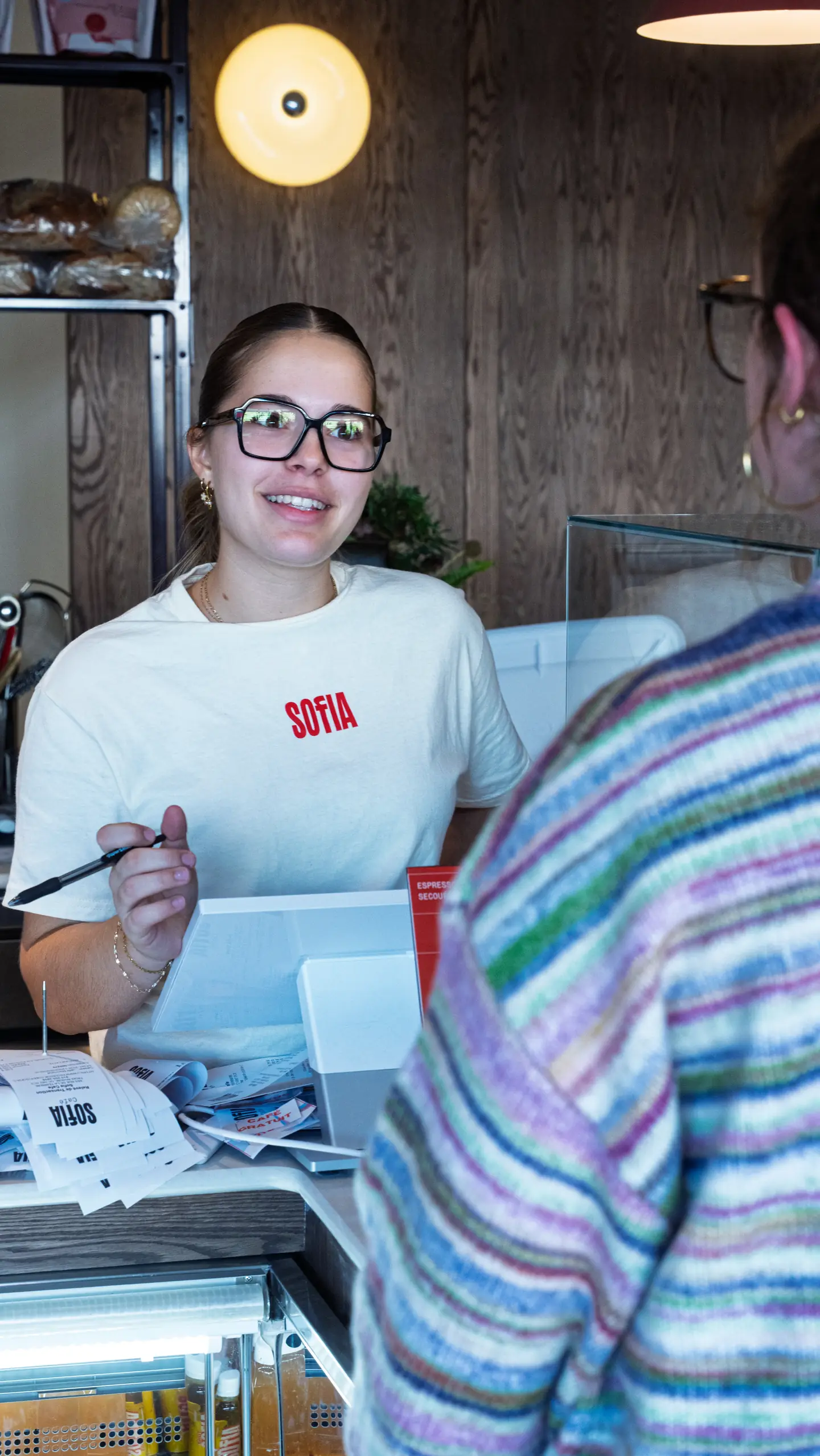 A smiling team member at the till