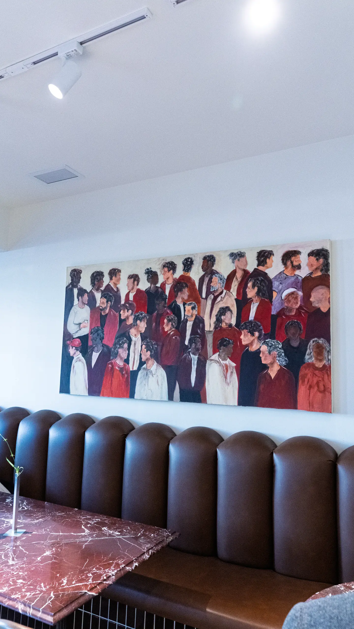 The leather bench seating under a large painting